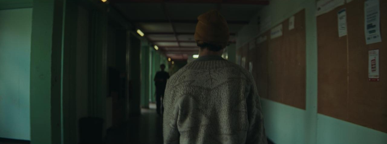 Benjamin de dos dans un couloir du lycée